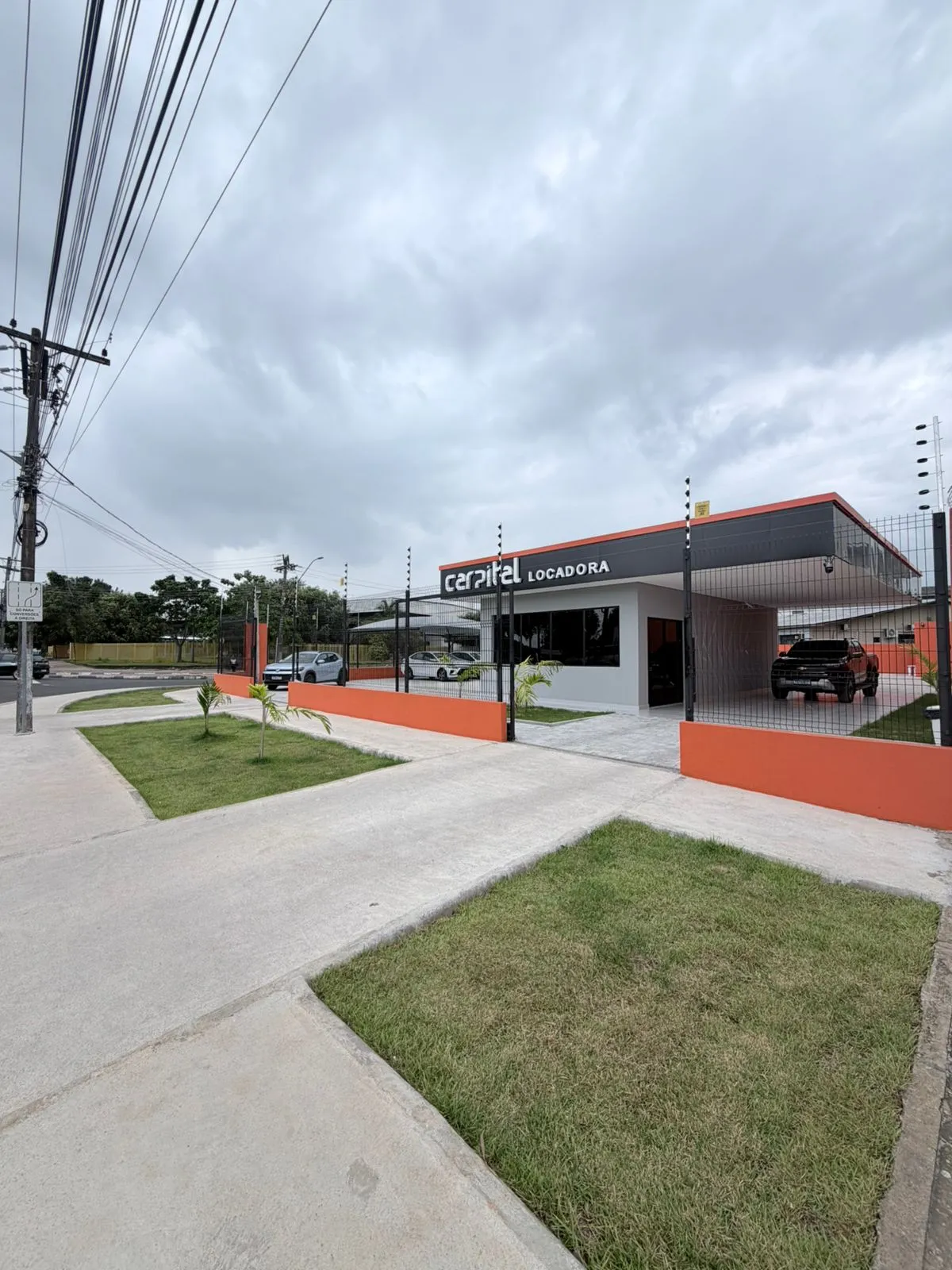Fachada da Carpital vista em ângulo, com paisagismo e calçada nova
